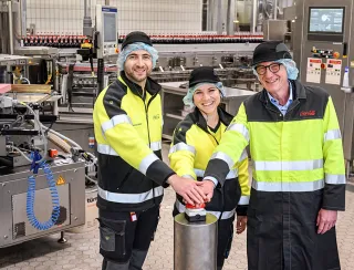 Zahlreiche Gäste wie Bürgermeister Guido Orthen (rechts) nahmen an der feierlichen Inbetriebnahme der modernisierten PET-Mehrweglinie am Coca-Cola Standort in Bad Neuenahr-Ahrweiler teil. Außerdem auf dem Bild links Hannes Bessinger (Betriebsleiter) und mittig Helen Schönknecht (Projektleiterin)